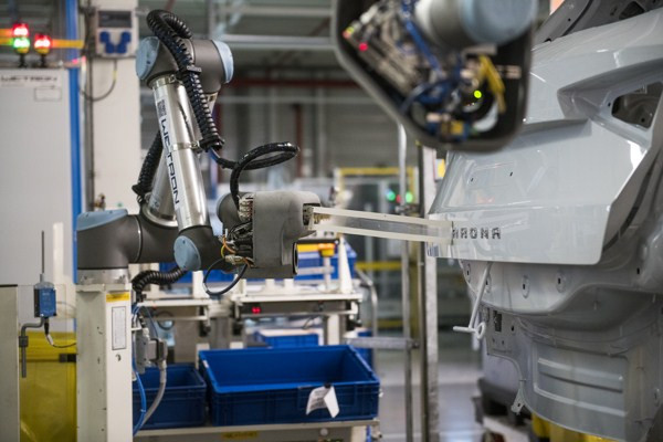 Un robot collaboratif fixe le lettrage du nom du modèle sur les voitures Seat
